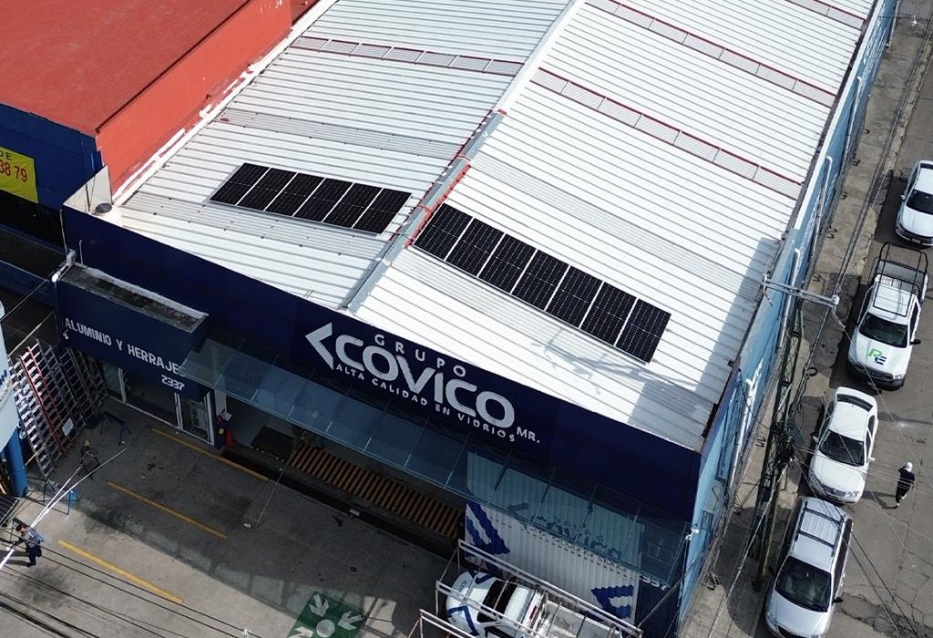 Vista aérea de paneles solares sobre el techo de lámina de una nave comercial